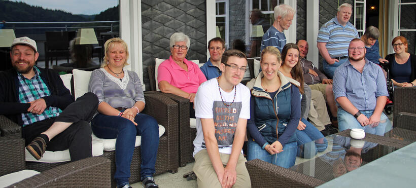 Die fünf engagierten Reisebegleiter mit Simone Ackerschott und der Gruppe auf der Terrasse von Haus Hammerstein. Foto: Weiße